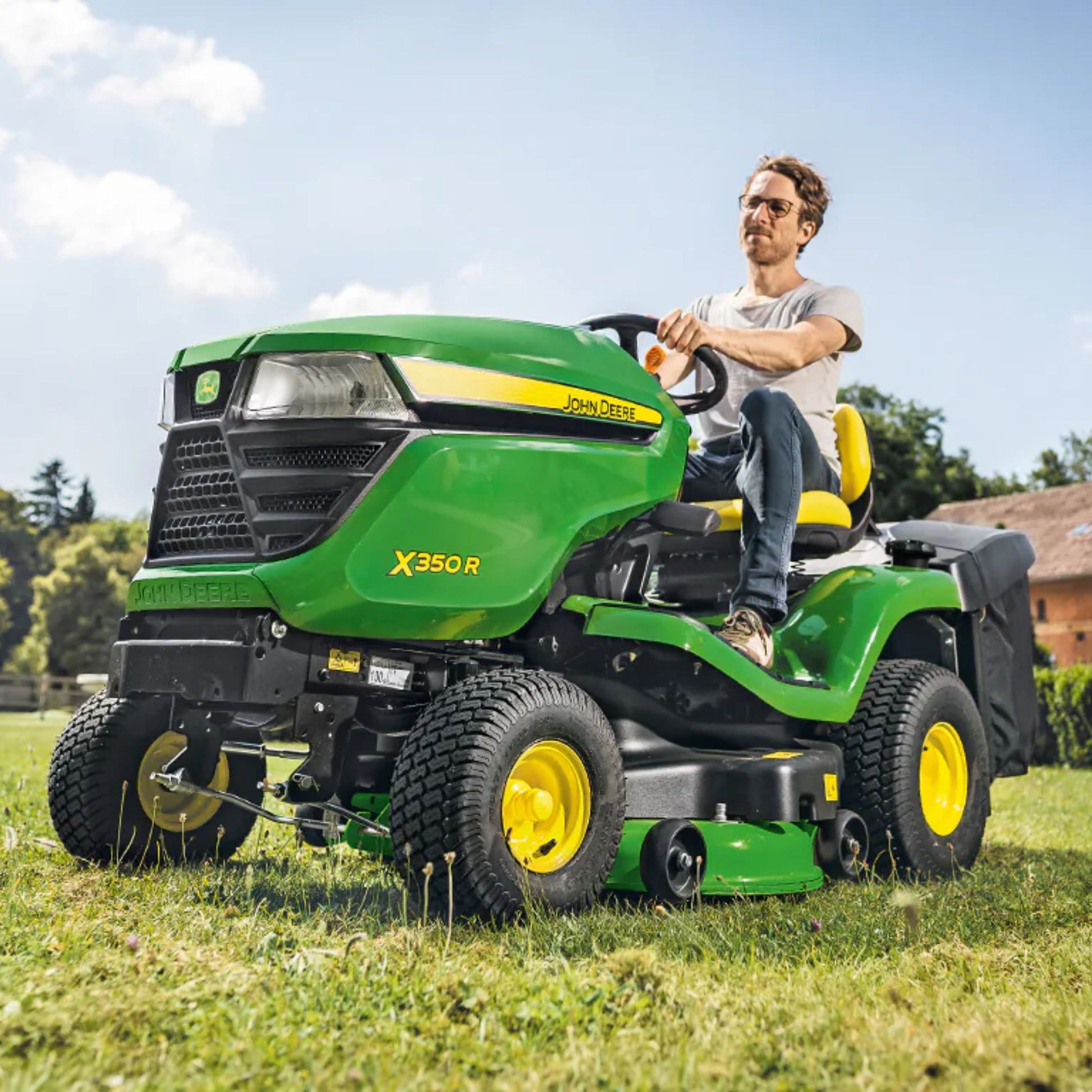 John_Deere_Ride_on_mower_X350R_mriding lawn tractor grey t-shirt and jeans