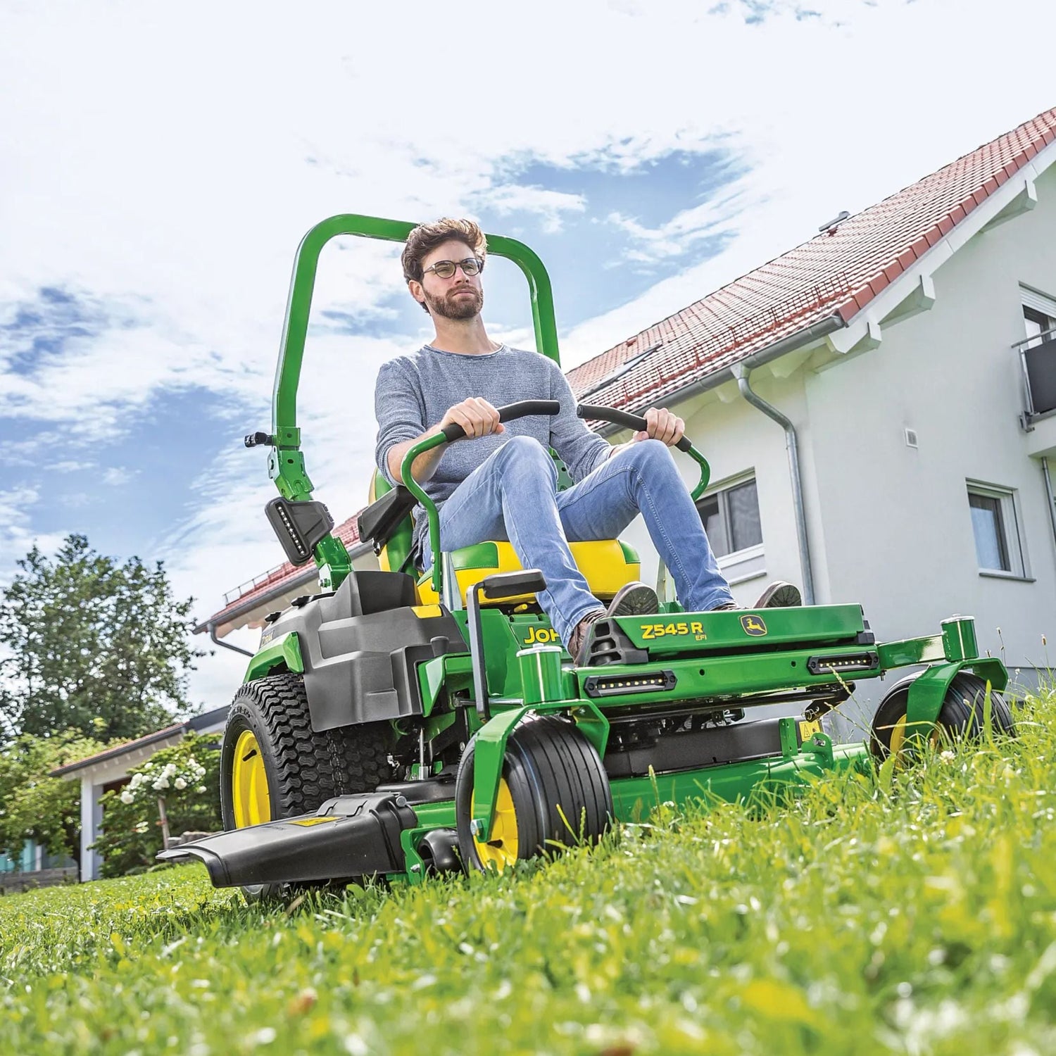 man riding green and yellow john deere zero turn mower